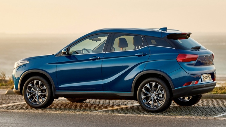 Vista lateral trasera de auto eléctrico Seres 3 color azul estacionado sobre asfalto con el mar de fondo.